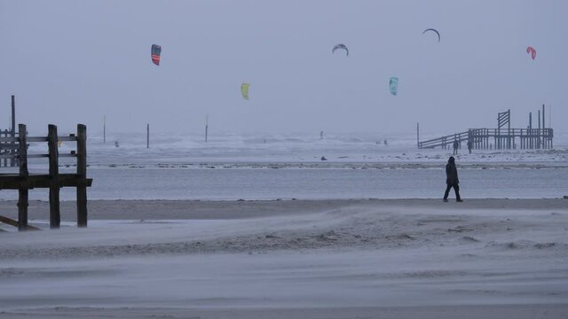 Kitesurfers on the beach in winter in St. Peter-Ording, Germany