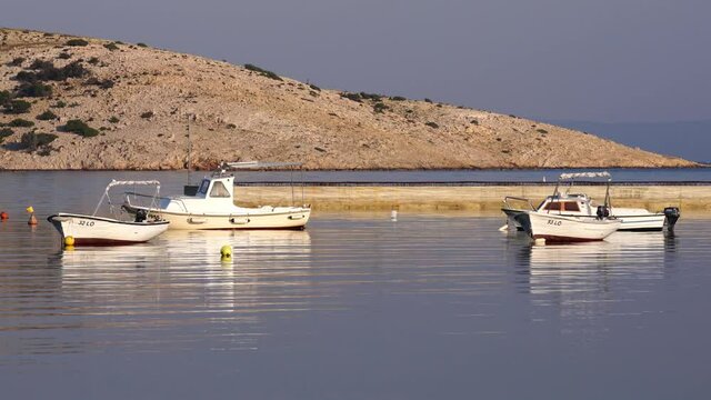 Motor boats in Lopar Bay at sunrise in the morning.