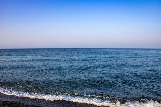 Morning with the calming waves of the Black Sea. On a warm sunny morning with blue cloudless skies. The coast of Sochi, Loo, Russia.