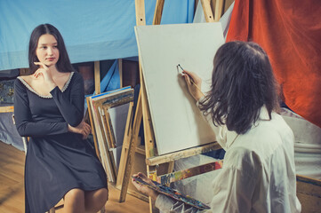 young artist paints a portrait of a beautiful girl
