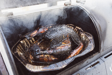 Smoked chicken cooking outdoor on a grill and smoker combination