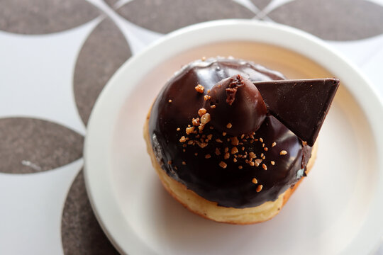 Traditional Israeli doughnut on a white plate. Chocolate doughnut close up photo. Authentic sweets of Middle East. 
