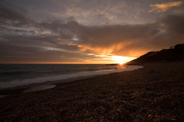 Sunset at Folkestone beach with moving clouds and the ocean.