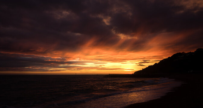 Right before the sun sets as seen from a beach in Folkestone, Kent. Cloudy evening.