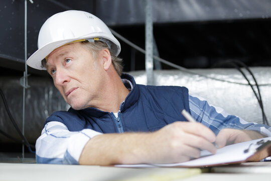 builder checking list on clipboard at construction site