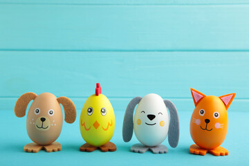 Easter holiday concept with cute handmade eggs, dogs, chicks and cat on blue background.