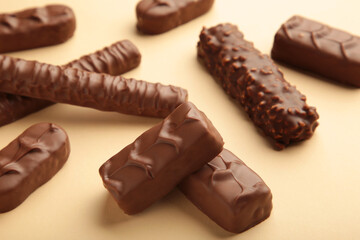 Mix of chocolate bars on beige background with copy space. Top view.