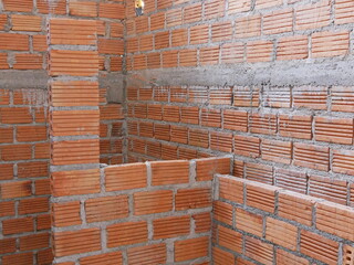 Classic red bricks laid to make a partition in a bathroom waiting to be plastered by cement