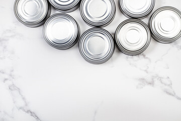Botes de conserva sobre un fondo blanco de mármol. Vista superior. Copy space