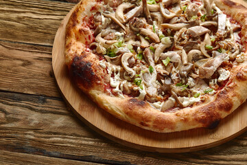 Delicious homemade pizza with mozzarella, mushrooms, beef and chicken. Wooden background, selective focus.