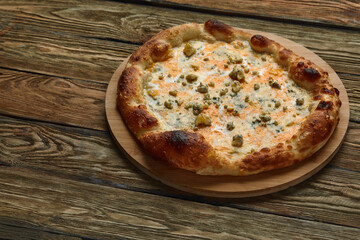 Italian Pizza Quattro formaggi on wooden table