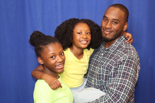 African American Family young girls with father black background