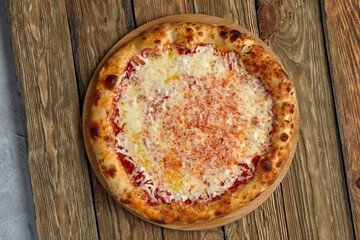 Pizza Margherita on wooden background, top view. Flyer and poster for Restaurants or pizzerias, template with delicious taste margarita pizza, mozzarella cheese