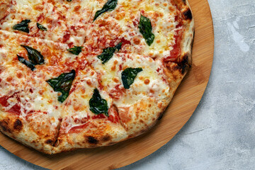 Whole neapolitan pizza served on wooden board