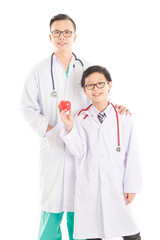 Fototapeta premium doctor and children in doctor costume holding red heart model, they stand on white background, heart health care