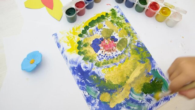 Little girl draws colorful abstract with flowers. Early development. Children's creativity . The concept of a happy childhood.
