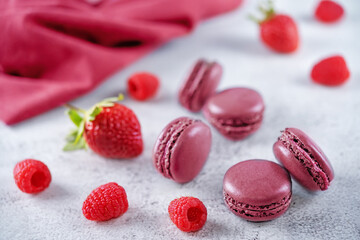 Obraz na płótnie Canvas Berries macarons with cream filling and fresh strawberries and raspberries