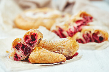Fresh delicious puff pastry with sweet cherries served on light table