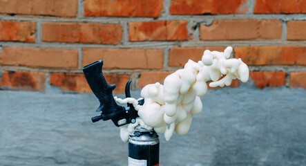 A gun for applying glue to foaming foam. Balloon foam.