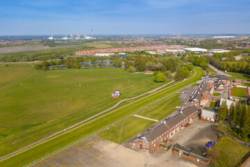 Aerial photo of the Pontefract race course located in the town of Pontefract in West Yorkshire in the UK, showing the main building and horse racing course, with the town of Castleford in the back