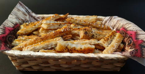 Close-up view of puff pastry salty sticks sprinkled with cumin and sesame seeds
