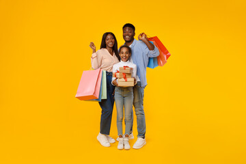 Happy black people holding shopping bags and gift boxes