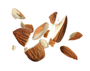 Pieces of tasty almonds falling on white background