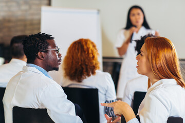 Doctor leading a seminar to group of healthcare workers and business people in convention center.