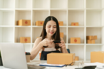 Small Business SME entrepreneur of Young Asian women working with smartphone for Online shopping at home,Cheerful and Happy with box for packaging in home,Own Business Start up for Business Online