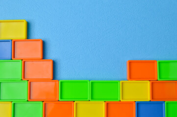 Plastic toy building blocks isolated on a blue background