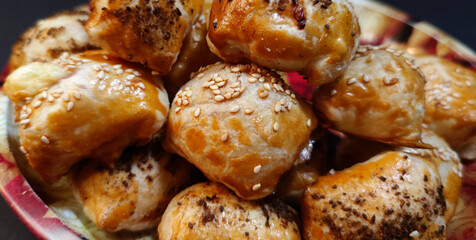 Close-up view of puff pastry ham rolls in a bowl, dark background
