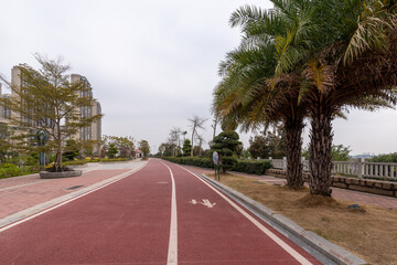 On a cloudy day, the red asphalt runway in the park