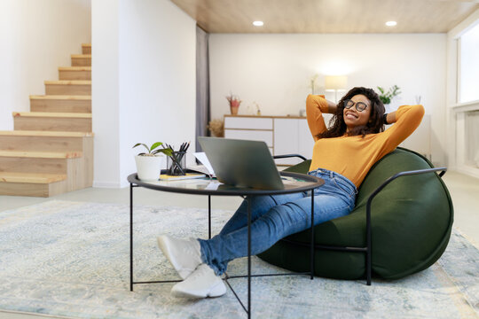 Smiling Black Woman Leaning Back Sitting At Desk