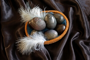 easter-themed photo of black eggs in a wicker plate on a black background