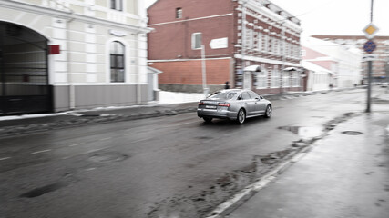 A city street with road infrastructure. A car passing along a city street.