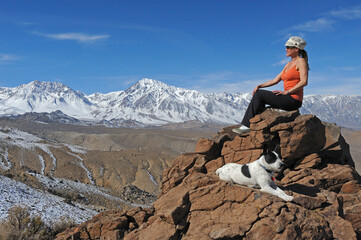 Woman and dog rest on rocky overlook, Inyo National Forest, CA