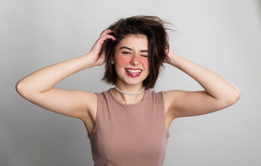 It's time to go to the beauty salon. Casual woman face expressions she does not go to spa, hair salon or beauty salon for long time. over gray background copy space.