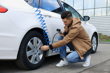 Handsome man inflating tire at car service