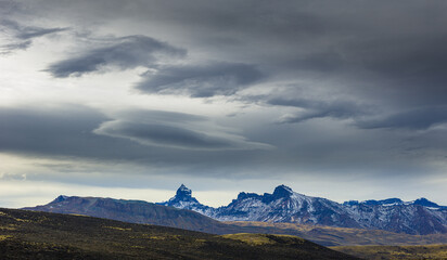 Fototapeta premium Jagged mountains in the mountain range Sierra Baguales under dark threatening sky, Patagonia, Chile