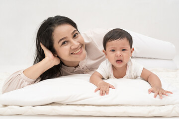 Mother and daughter happily playing on the couch.