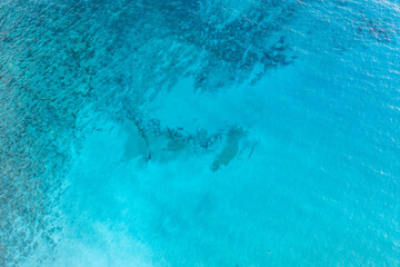 Sea surface turquoise blue color background, aerial drone view. Calm clear water with small ripples
