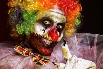 Portrait of terrifying clown on black background, closeup. Halloween party costume