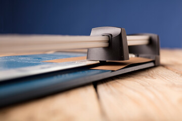 The blue paper guillotine used during the home office. Paper cutter blue background