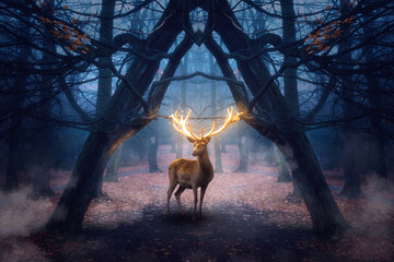 Mystischer Hirsch mit leuchtendem Geweih steht in einem düsteren Wald mit Nebel