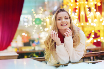 happy blond girl in red scarf close up portrait on decorated Christmas city mall background