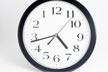 Black classic clock on isolated white background.