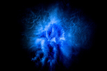 Explosion of blue, navy color, fluid and neoned powder on dark studio background with copy space