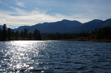 Sun glare reflected on the surface of the mountain river.