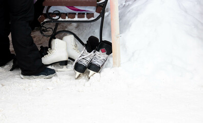 Figure skates lie on the white snow near the bench.The concept of a healthy lifestyle in winter....