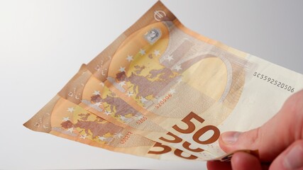 Man gives 50 euro banknotes with his hand